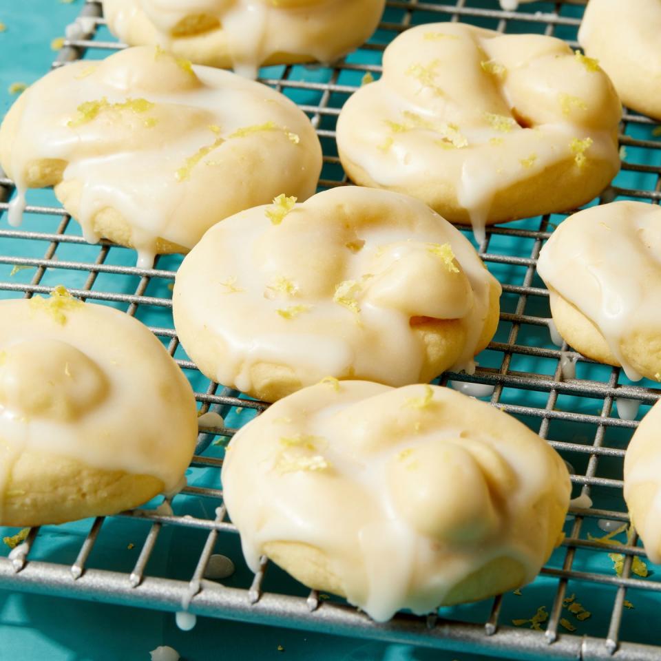 italian lemon cookies shaped like knots, drizzled in lemon glaze, and topped with lemon zest