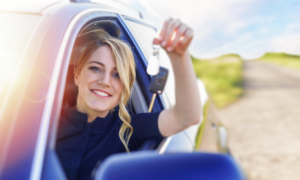 A beautiful blonde woman holds a car key in her hand. Woman car driver.