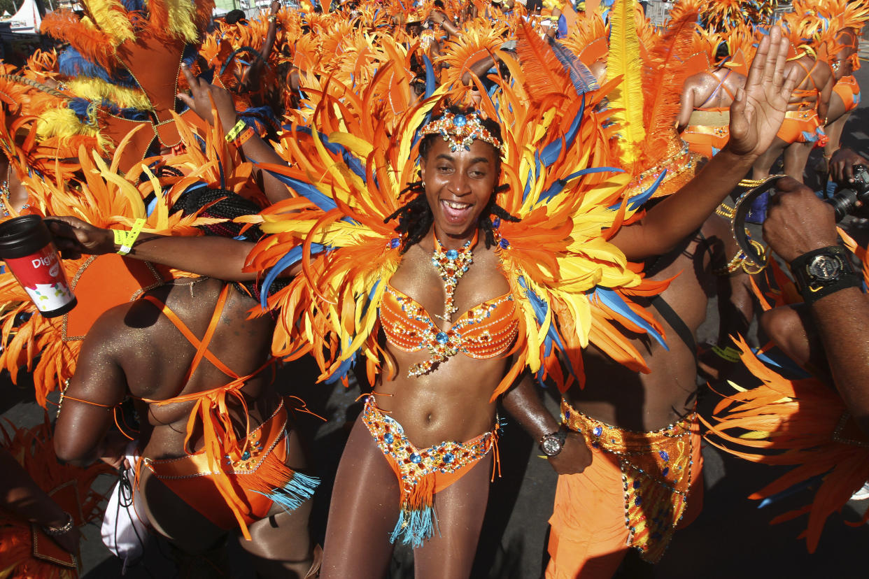 PORT OF SPAIN, TRINIDAD - FEBRUARY 17:  Masqueraders from the band 'Ah Come Back Home' by Ronnie & Caro dance in the Queen's Park Savannah during the Parade of Bands as part of Trinidad and Tobago Carnival on February 17, 2015 in Port of Spain, Trinidad. (Photo by Sean Drakes/LatinContent via Getty Images)