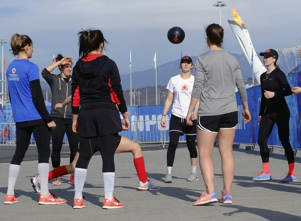 In this , Wednesday, Feb. 12, 2014, photo, members of the Canadian women's ice hockey team warm up outside before their game against the United States during the 2014 Winter Olympics women's ice hockey tournament at Shayba Arena, in Sochi, Russia. (AP Photo/J. David Ake)