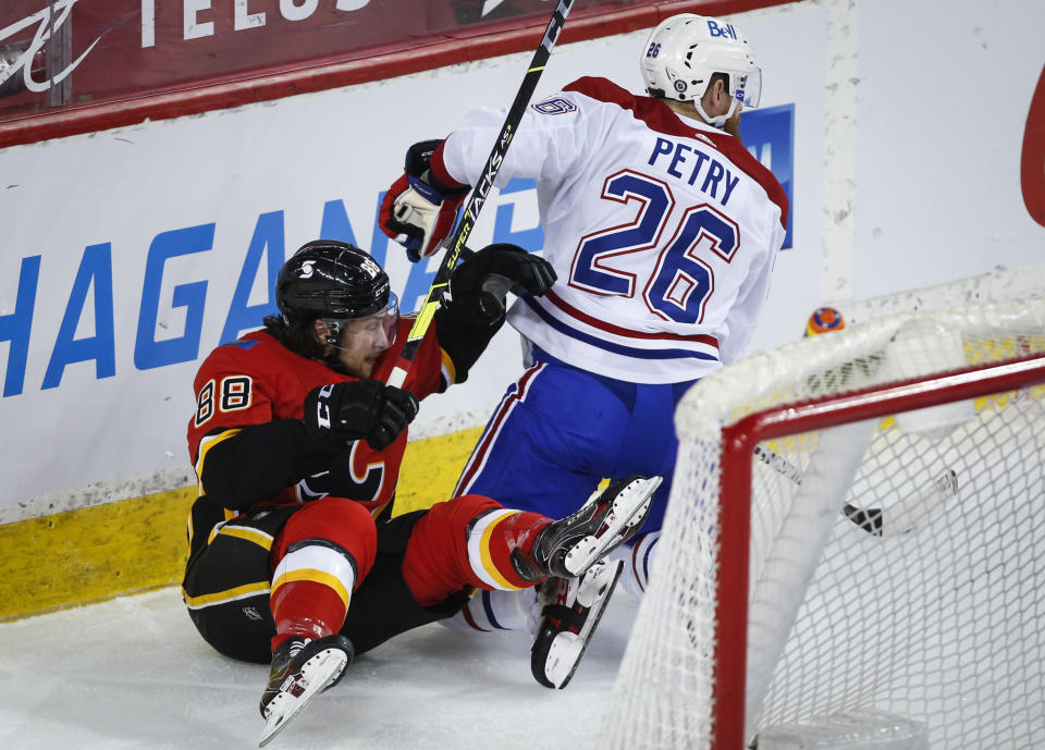 Montreal Canadiens' Jeff Petry, right, checks Calgary Flames' Andrew Mangiapane during the third period of an NHL hockey game Friday, April 23, 2021, in Calgary, Alberta. (Jeff McIntosh/The Canadian Press via AP)