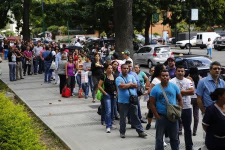 People line up outside a pharmacy to buy baby diapers in Caracas January 19, 2015. REUTERS/Jorge Silva