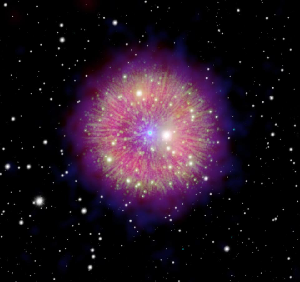 Supernova-Überrest hellrosa kreisförmige Blase im Weltraum mit dunkelblauem Halo und grün-gelben Strängen, die wie Speichen von einem blauen Punkt in seinem Zentrum ausgehen