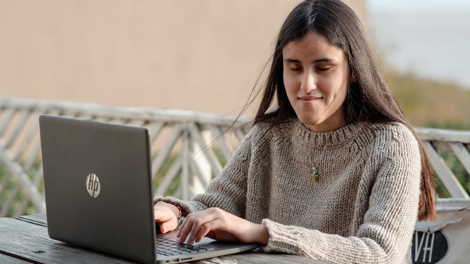 Milagros escribiendo en su computadora