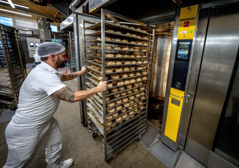 An employee pushes rolls into one of the gas heated ovens in the producing facility in Neu Isenburg, Germany, Monday, Sept. 19, 2022. Andreas Schmitt, head of the local bakers' guild, said some small bakeries are contemplating giving up due to the energy crisis. (AP Photo/Michael Probst)