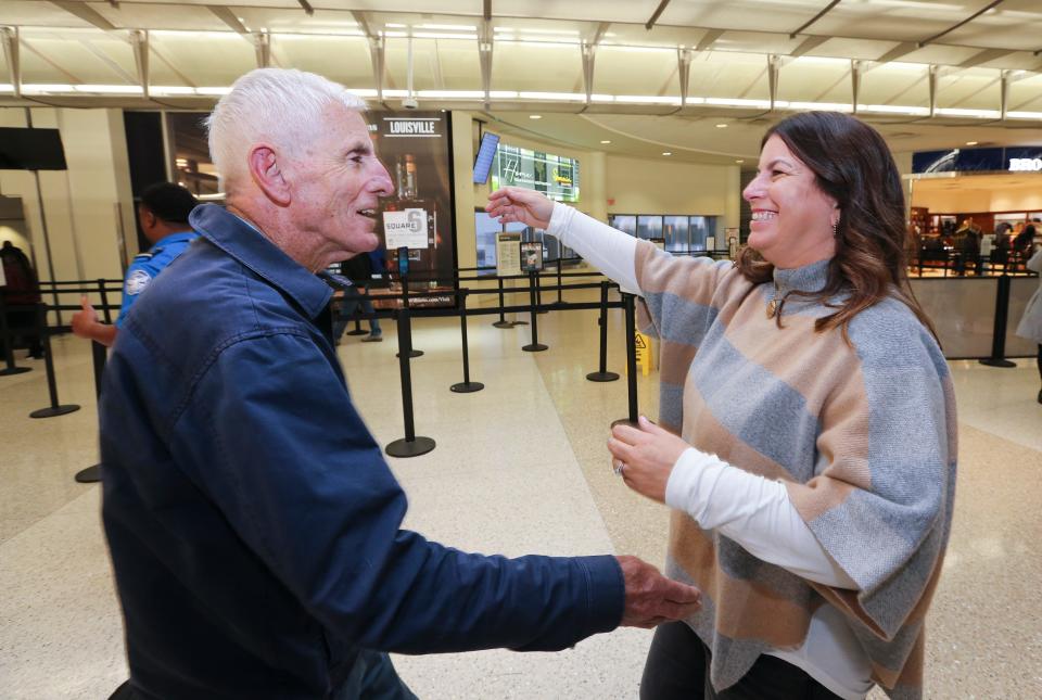 Nancy Galloway, 53, right, embraced her dad Alan Freedman, 82, as he arrived at the Louisville Muhammad Ali International Airport in Louisville, Ky. on Nov. 15, 2022.  Galloway used DNA testing to identify Freedman as her father and located him in Australia.