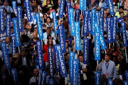 Delegates hold Hillary signs. REUTERS/Rick Wilking.