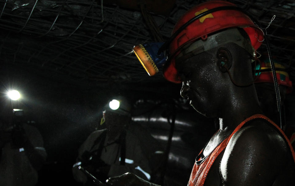 In this photo taken Thursday, Feb. 20, 2014, a miner is photographed underground during a journalist's tour to the South Deep gold mine south of Johannesburg. Miners work some 2.4 kilometers (1.5 miles) underground in 12-hour shifts, where safety is a constant concern and everyone depends on everyone else to stick to precautions. (AP Photo/Themba Hadebe)