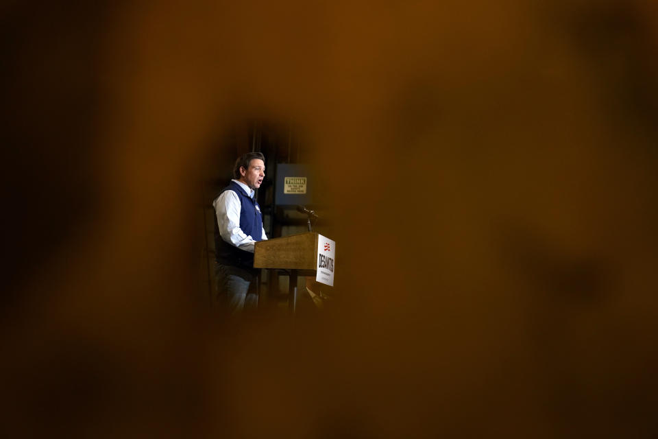 Republican presidential candidate Florida Gov. Ron DeSantis is seen through a hole in a welders curtain as he speaks during a campaign event at Port Neal Welding, Wednesday, May 31, 2023, in Salix, Iowa. (AP Photo/Charlie Neibergall)