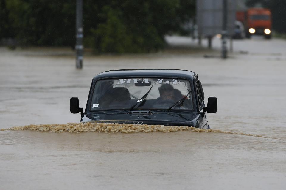 A man drives his car through a flooded street in the town of Lazarevac, south of Belgrade May 15, 2014. (REUTERS/Marko Djurica)