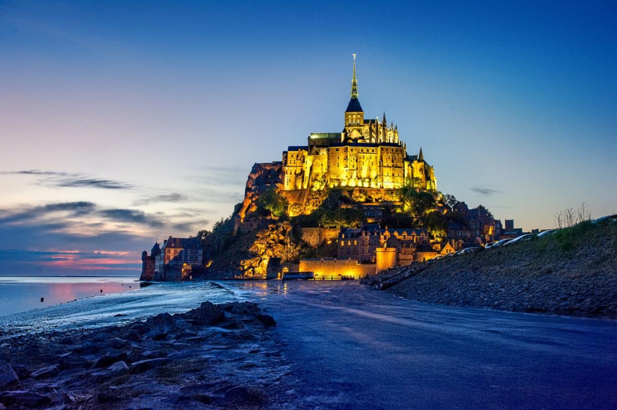Check out everything there is to know about the Mont-Saint-Michel in Normandy. Pictured: Mont-Saint-Michel at high tide during the night with glowing lights