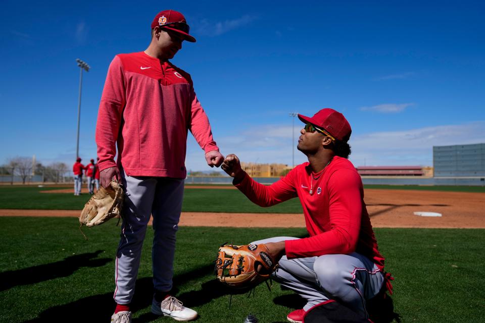 Cincinnati Reds third baseman Spencer Steer and shortstop Jose Barrero first bump after infield drills. The Reds are promoting versatility on defense at spring training.