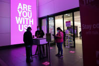 Shoppers talk to a sales person outside of a T-Mobile store Thursday, Nov. 19, 2020, in Santa Monica, Calif. California Gov. Gavin Newsom is imposing an overnight curfew as the most populous state tries to head off a surge in coronavirus cases. On Thursday, Newsom announced a limited stay-at-home order in 41 counties that account for nearly the entire state population of just under 40 million people. (AP Photo/Marcio Jose Sanchez)