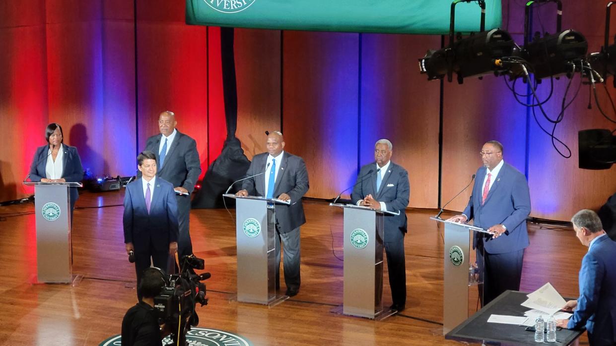 Candidates for Jacksonville sheriff (left to right behind the podiums) Lakesha Burton, Wayne Clark, Tony Cummings, Ken Jefferson and T.K. Waters take part in a televised forum with  Jacksonville University Public Policy Institute Executive Director Rick Mullaney in front.