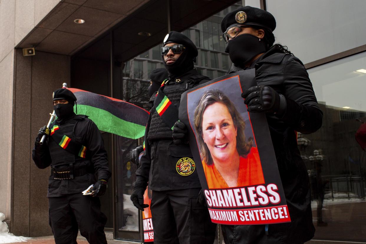 Members of the New Black Panthers stand with signs calling for a maximum sentence for former Brooklyn Center Police Officer Kim Potter, Friday, Feb. 18, 2022 in Minneapolis. 