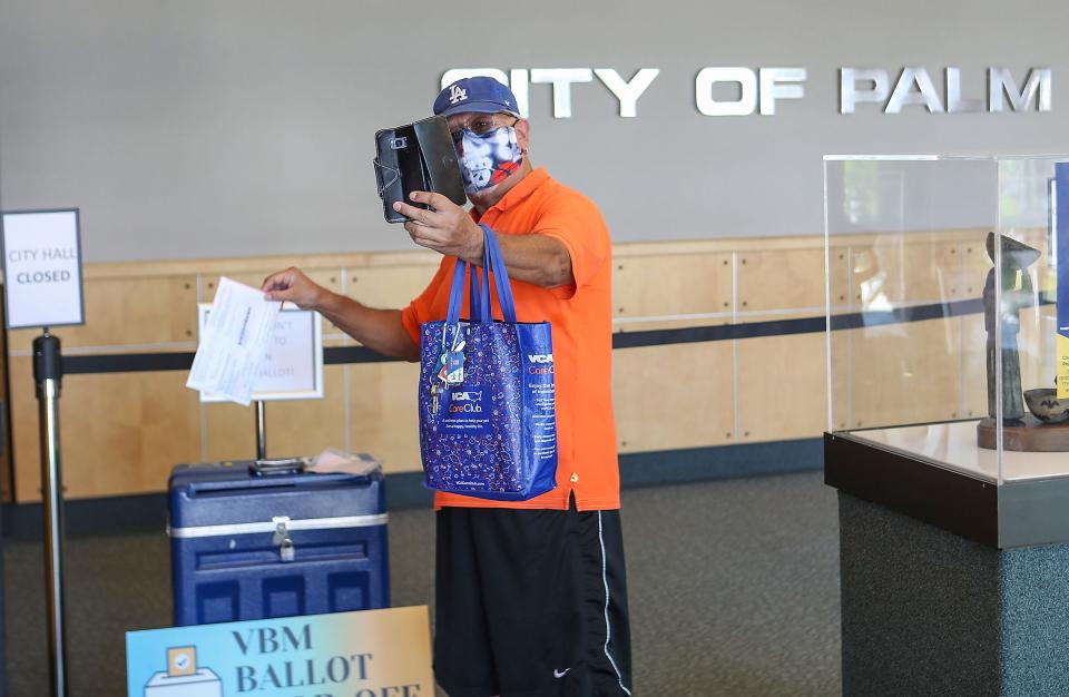 Palm Springs resident Henry Chinchilla takes a selfie as he drops his Vote by Mail ballot off at Palm Springs City Hall, October 13, 2020.