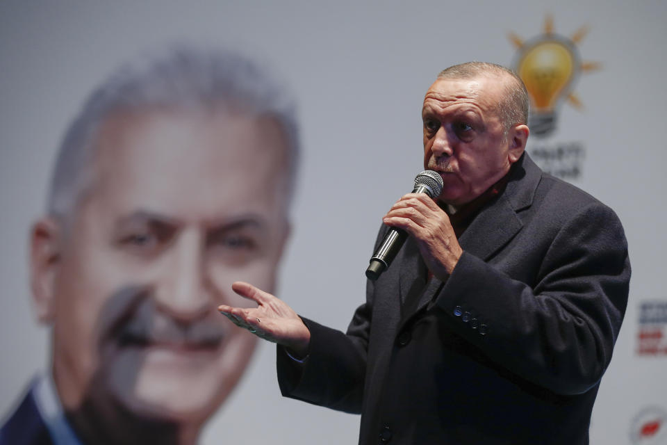 Turkey's President Recep Tayyip Erdogan addresses the supporters of his ruling Justice and Development Party, AKP, at a rally in Istanbul, late Tuesday, March 19, 2019, ahead of local elections scheduled for March 31, 2019. An image of AKP's mayoral candidate for Istanbul, Binali Yildirim, is seen in the background. (AP Photo/Emrah Gurel)