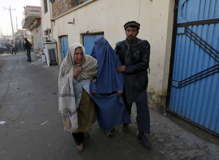 An injured Afghan woman is assisted by her relatives after she was wounded by a suicide attack Kabul, Afghanistan, December 28, 2015. REUTERS/Mohammad Ismail