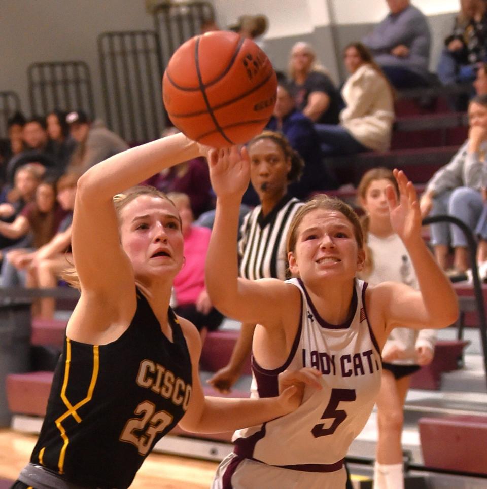 Cisco's Pearson Hearne, left, tries to catch a pass as Hawley's Kynzi O'Shields defends in the second half. Cisco beat the Lady Cats 61-22 in the District 10-2A game Friday at Hawley.