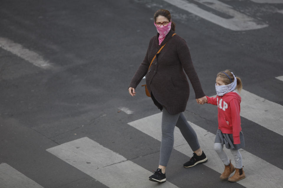 A pregnant women and her daughter seen walking in Paris, on April 12, 2020, during the lockdown in France to attempt to halt the spread of the novel coronavirus COVID-19.   (Photo by Mehdi Taamallah/NurPhoto via Getty Images)