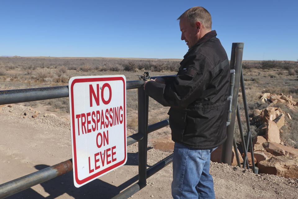 Public works director Tim Westover shuts the gate to a levee designed to hold back the Little Colorado River in Winslow, Arizona, on Feb. 4, 2022. The U.S. Army Corps of Engineers recently announced a flood control project in the city would receive $65 million in funding. (AP Photo/Felicia Fonseca)