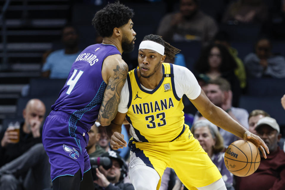 Indiana Pacers center Myles Turner (33) drives into Charlotte Hornets center Nick Richards, left, during the first half of an NBA basketball game in Charlotte, N.C., Monday, Feb. 12, 2024. (AP Photo/Nell Redmond)