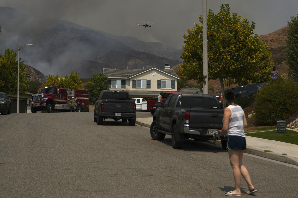 Residents watch as crews battle the Line Fire in Highland, Calif., on Sept. 7.