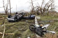 Overturned vehicles are seen at a rice field after super Typhoon Haiyan battered Tacloban city, central Philippines, November 9, 2013. Possibly the strongest typhoon ever to hit land devastated the central Philippine city of Tacloban, killing at least 100 people, turning houses into rubble and leveling the airport in a surge of flood water and high wind, officials said on Saturday. The toll of death and damage from Typhoon Haiyan on Friday is expected to rise sharply as rescue workers and soldiers reach areas cut off by the massive, fast-moving storm which weakened to a category 4 on Saturday. REUTERS/Romeo Ranoco (PHILIPPINES - Tags: DISASTER TPX IMAGES OF THE DAY ENVIRONMENT)