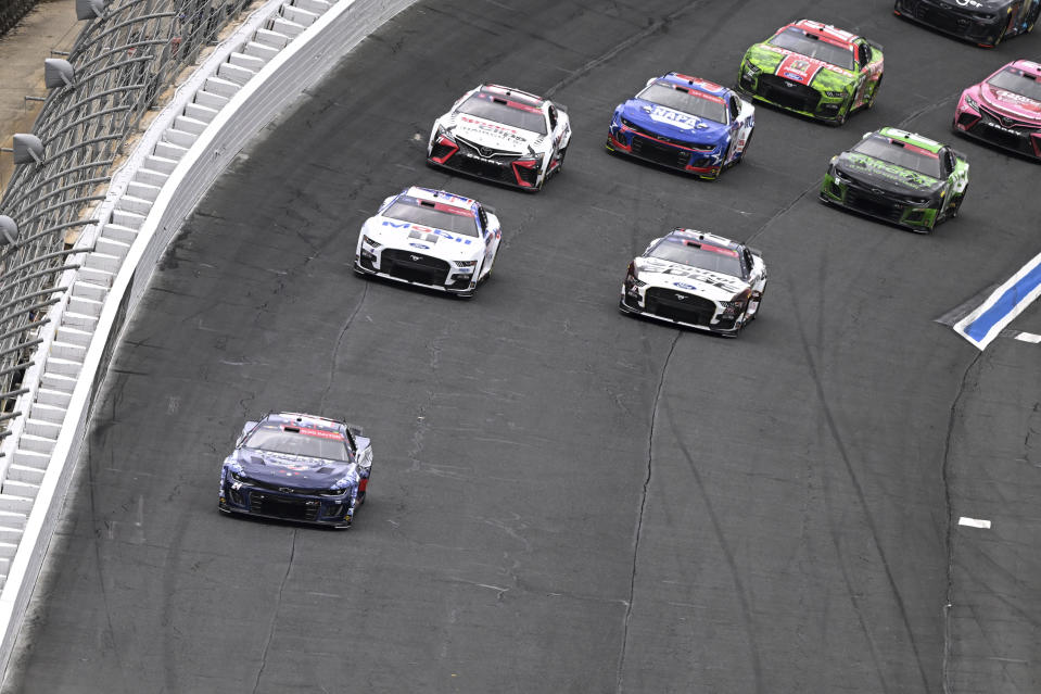 William Byron (24) leads a pack of cars out of Turn 4 during a NASCAR Cup Series auto race at Charlotte Motor Speedway, Monday, May 29, 2023, in Concord, N.C. (AP Photo/Matt Kelley)