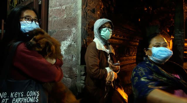 Villagers wear masks as they prepare to evacuate from their homes located near to the crater. Photo: AAP