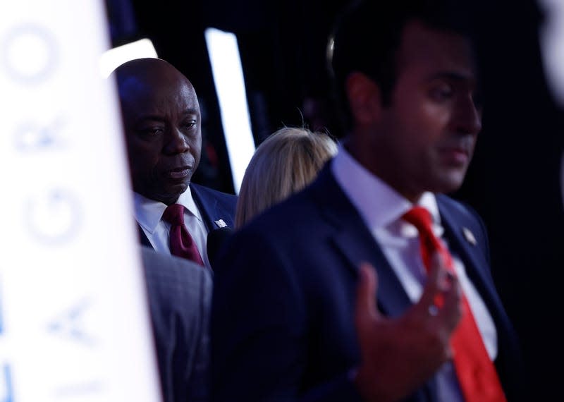 MIAMI, FLORIDA - NOVEMBER 08: Republican presidential candidate U.S. Sen. Tim Scott (R-SC) speaks to members of the media as he is seen behind fellow candidate Vivek Ramaswamy in the spin room following the NBC News Republican Presidential Primary Debate at the Adrienne Arsht Center for the Performing Arts of Miami-Dade County on November 8, 2023 in Miami, Florida. Five presidential hopefuls squared off in the third Republican primary debate as former U.S. President Donald Trump, currently facing indictments in four locations, declined again to participate. 