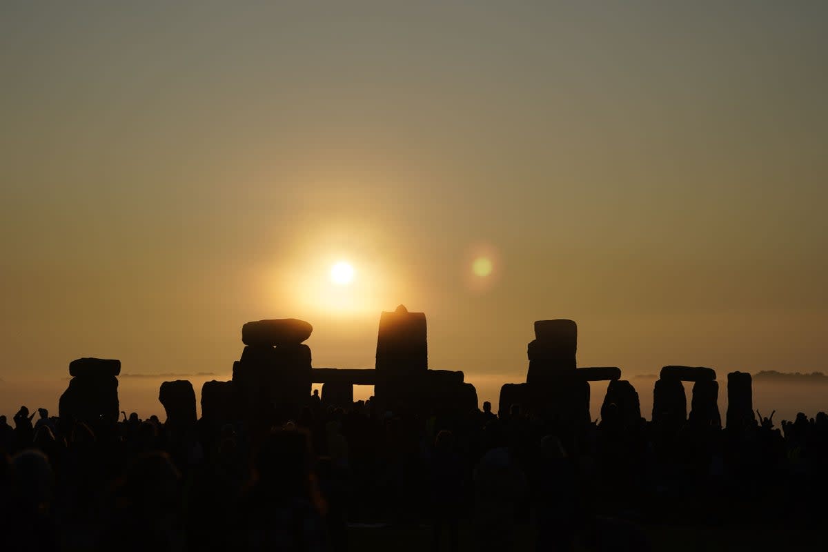 People gather during sunrise as they take part in the summer solstice at Stonehenge in Wiltshire in June 2023 (PA Wire)