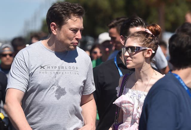 <p>ROBYN BECK/AFP via Getty </p> SpaxeX founder Elon Musk (L) and Canadian musician Grimes (Claire Boucher) attend the 2018 Space X Hyperloop Pod Competition, in Hawthorne, California on July 22, 2018.