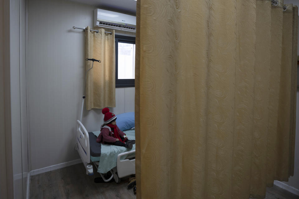 A Palestinian child sits at hospitals bed next to his mother who is under medical treatment for being infected with COVID-19, at the coronavirus ward inside the Palestinian Medical Complex, in the West Bank city of Ramallah, Thursday, Feb. 3, 2022. Palestinians are facing a winter coronavirus surge driven by the omicron variant, placing stress on the medical system even though vaccines are widely available. (AP Photo/Nasser Nasser)