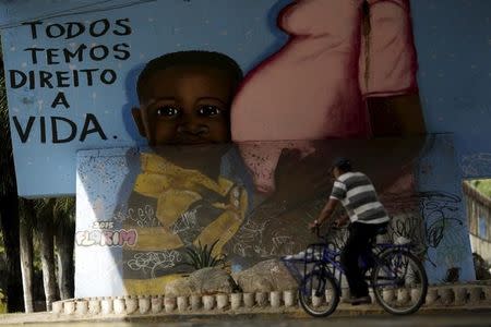 A man walks in front of a graffiti of pregnancy on an overpass in Recife, Brazil, February 4, 2016. REUTERS/Ueslei Marcelino