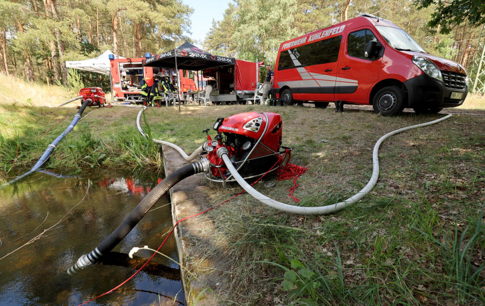 Die Feuerwehr ist im Einsatz beim Waldbrand auf dem ehemaligen Truppenübungsplatz und pumpt Wasser zum Löschen  aus einem Wasserlauf. (Foto: Bernd Wüstneck/dpa)