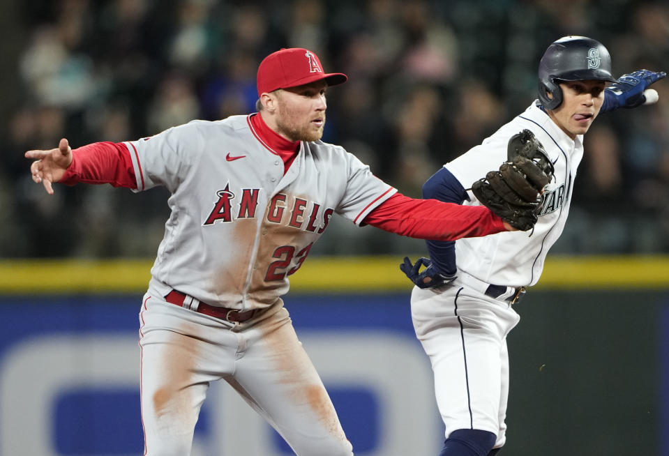 Los Angeles Angels second baseman Brandon Drury, left, and Seattle Mariners' Sam Haggerty, right, look for the call during the fifth inning of a baseball game Tuesday, April 4, 2023, in Seattle. Haggerty was called out at second base after hitting a single. (AP Photo/Lindsey Wasson)