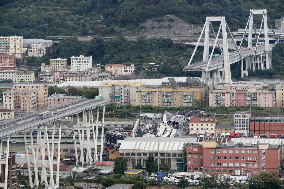 FILE - In this Tuesday, Aug. 14, 2018 file photo, cars are blocked on the Morandi highway bridge after a section of it collapsed, in Genoa, northern Italy. Italy's government says it has scored a victory in a battle stemming from the deadly 2018 collapse of Genoa's bridge, with the Benetton fashion family agreeing to exit the holding company that manages and maintains most of Italy's toll roads and bridges. (AP Photo/Antonio Calanni, File)