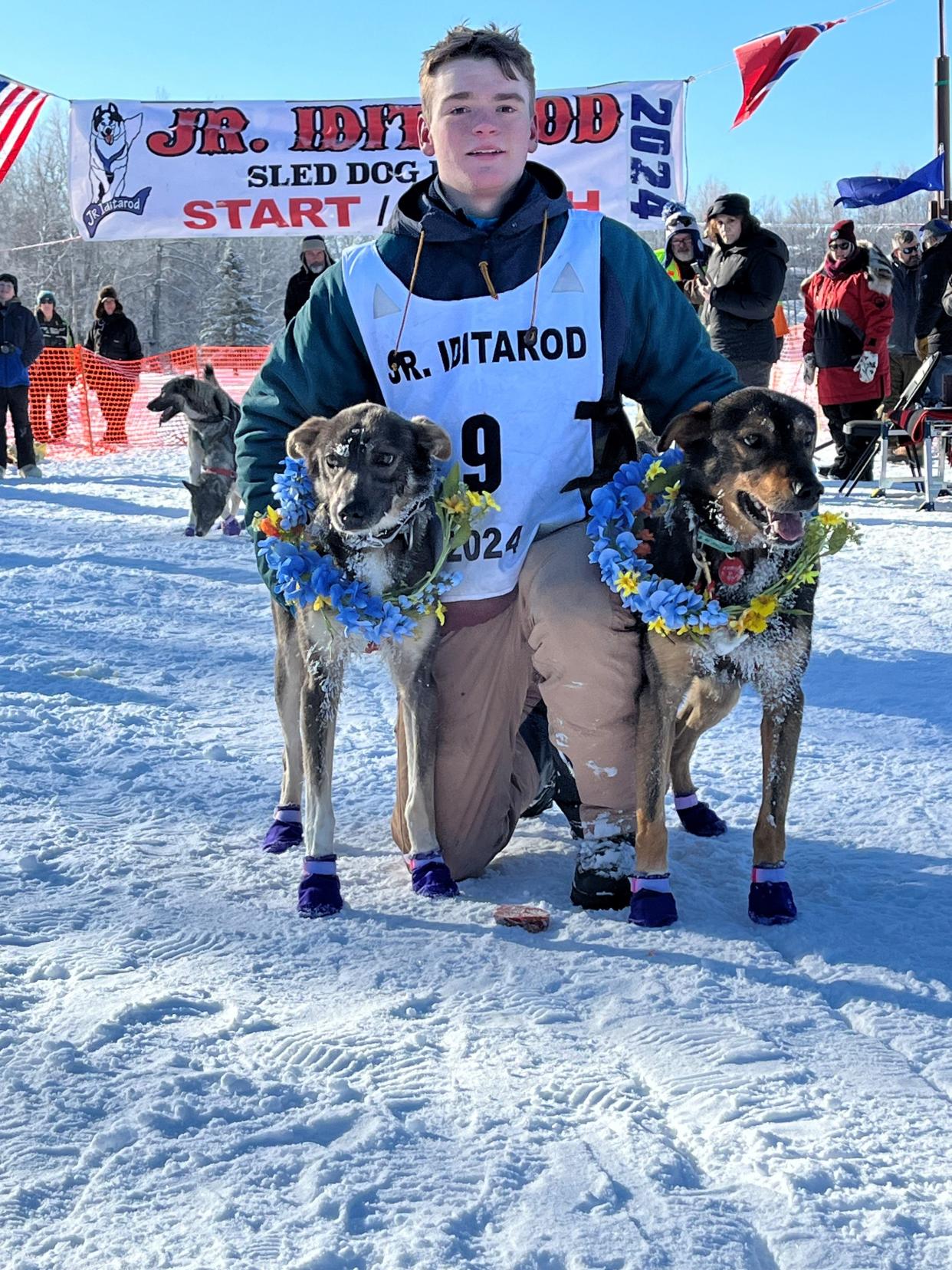 Morgan Martens, 17, of Brule, poses for a photo with two dogs, Rivet and Earhearta, from the 10-dog team he ran to second place at this year's Junior Iditarod in Alaska.