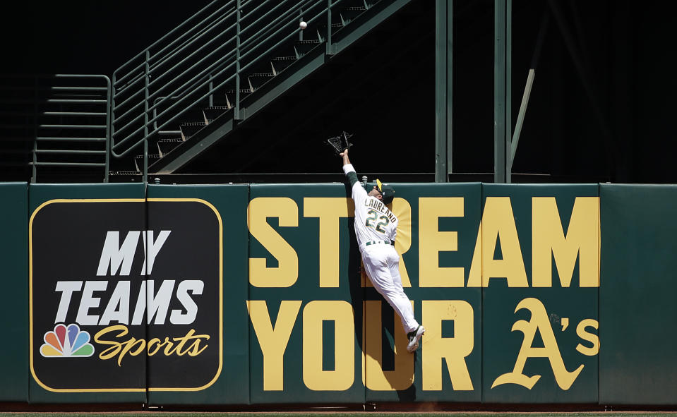 Oakland Athletics center fielder Ramon Laureano jumps to catch a fly ball hit by Toronto Blue Jays' Teoscar Hernandez during the second inning of a baseball game in Oakland, Calif., Sunday, April 21, 2019. (AP Photo/Jeff Chiu)