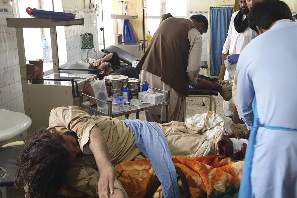 Pakistani paramedics treat men, who were injured in a fighting between Afghan security forces and Taliban in SpinBoldak border area, at a hospital in Chaman, Pakistan, Friday, July 16, 2021. Afghan government security forces were battling to retake the southeastern SpinBoldak border crossing with neighbor Pakistan Friday, according to Afghanistan's deputy defense ministry spokesman Fawad Awan. (AP Photo/Tariq Achakzai)