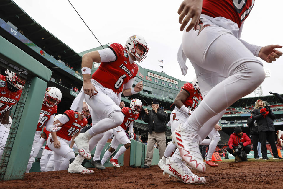 Louisville takes the field before the Fenway Bowl NCAA college football game against Cincinnati at Fenway Park, Saturday, Dec. 17, 2022, in Boston. (AP Photo/Winslow Townson)