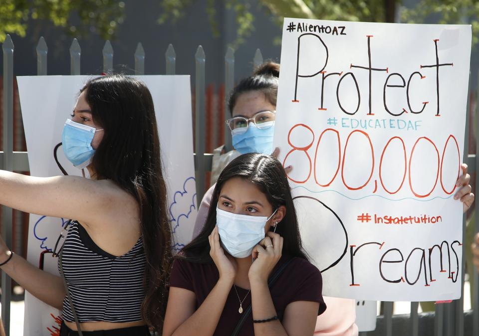 Deferred Action for Childhood Arrivals recipients listen to speakers during a news conference in front of the U.S. Immigration and Customs Enforcement building after the U.S. Supreme Court ruled on the DACA program Thursday, June 18, 2020, in Phoenix. The U.S. Supreme Court ruled President Donald Trump improperly ended the program that protects immigrants brought to the country as children and allows them to legally work, keeping the people enrolled in DACA. (AP Photo/Ross D. Franklin)