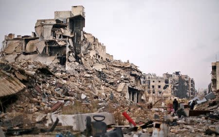 People carry belongings as they walk on the rubble of damaged buildings in the government controlled area of Aleppo, Syria December 17, 2016. REUTERS/ Omar Sanadiki