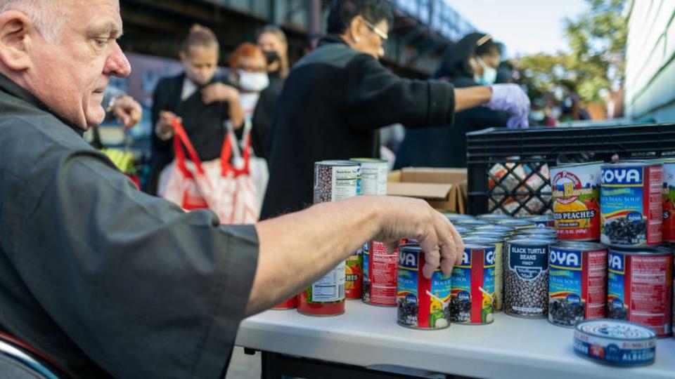 Un hombre repartiendo comida en un banco de alimentos en EEUU.