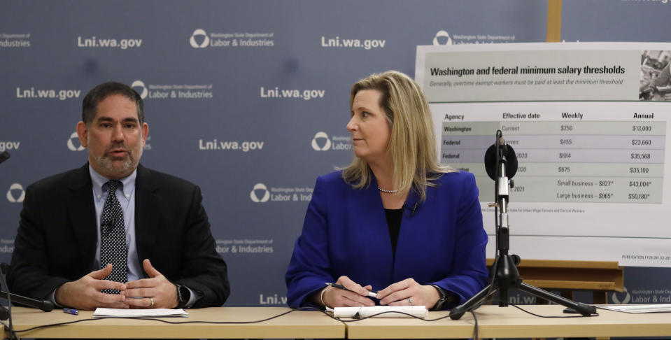 Washington state Labor and Industries Director Joel Sacks, left, and Deputy Director Elizabeth Smith talk about new overtimes rules during a news conference Wednesday, Dec. 11, 2019, in Tukwila, Wash. Washington state adopted some of the nation's strongest overtime rules, allowing hundreds of thousands of workers who have been exempt to begin collecting when they work more than 40 hours per week. Supporters say it's an important step in restoring America's middle class. (AP Photo/Elaine Thompson)