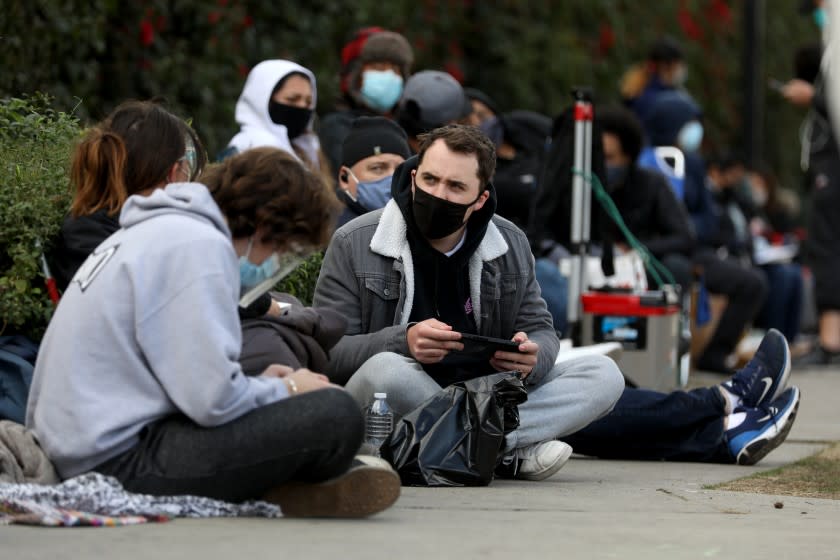 LOS ANGELES, CA - JANUARY 22: People wait in the standby line to receive a COVID-19 vaccination at Kedren Community Health Center on Friday, Jan. 22, 2021 in Los Angeles, CA. People younger than 65 are getting the COVID-19 vaccine. They are getting a vaccine by waiting on standby. When people do not show up for their appointment, rather than let the vaccine go to waste, the health center is administering on a first come first serve. (Gary Coronado / Los Angeles Times)