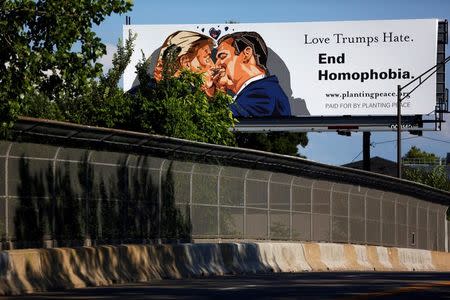 A billboard erected in advance of the Republican National Convention depicts U.S. Republican presidential candidate Donald Trump kissing former presidential candidate Sen. Ted Cruz (R-TX) in Cleveland, Ohio July 15, 2016. REUTERS/Aaron P. Bernstein