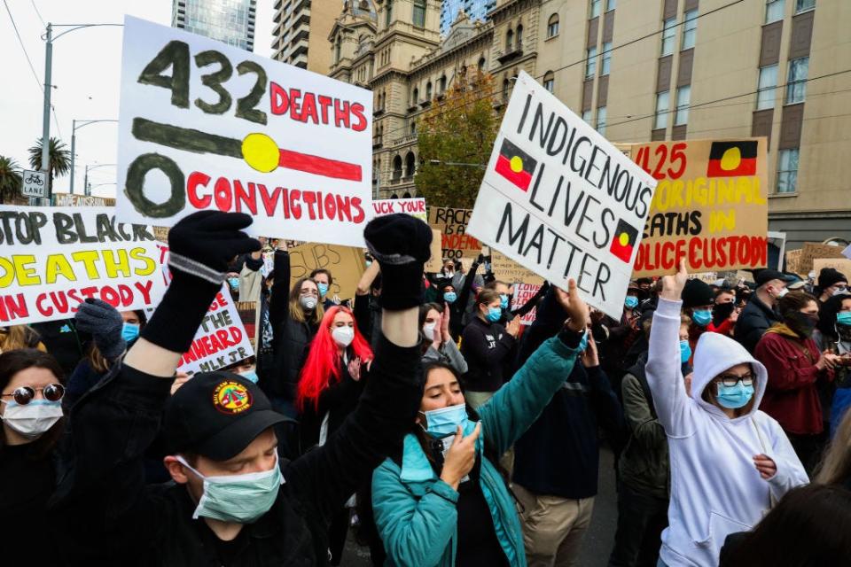 A protester in Melbourne holds a sign referencing the 432 Indigenous people reported to have died in police custody in Australia since 1991.