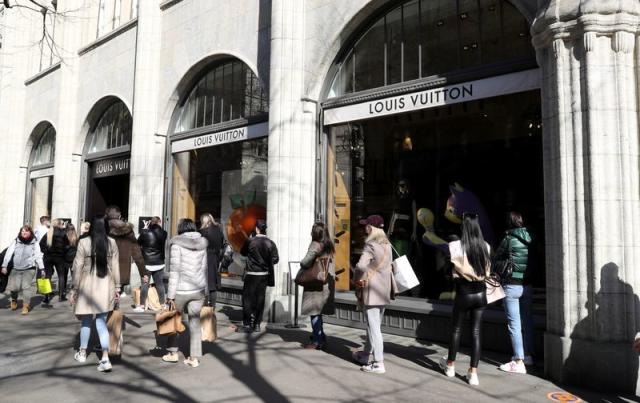 FILE--Pedestrians walk past a Louis Vuitton (LV) boutique of LVMH